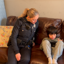 Ofc. Sarah Fine with 6-year-old Gabriel, playing on an iPad.
